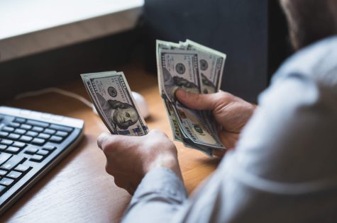 businessman-is-counting-dollars-banknotes-PCFS7CHJPG.jpg